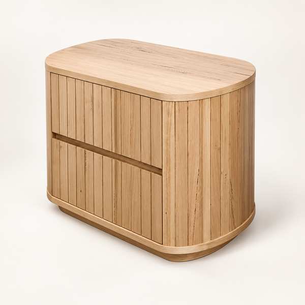 A light natural wood side table with rounded edges, featuring two front drawers with horizontal recessed handles and a slatted wood design, shown on a clean off-white background.