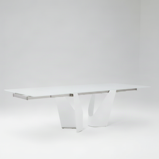 A modern white rectangular dining table with a sleek sculptural base, shown in a minimalist white studio setting.