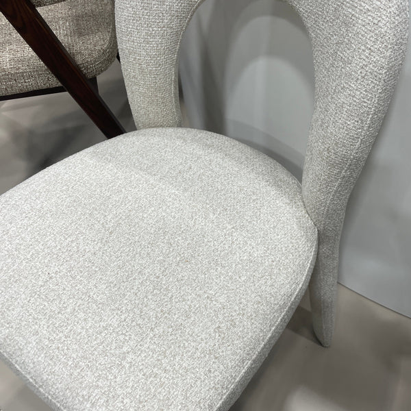 Close-up of upholstered chair seat in light textured fabric with curved wooden legs