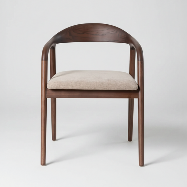 A modern wooden dining chair with a curved backrest, slim tapered legs, and a light beige upholstered seat cushion, shown against a neutral light gray background.