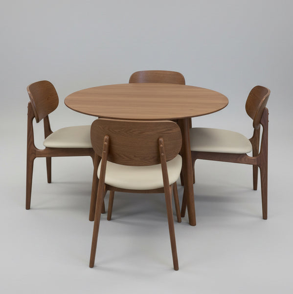 Wooden dining table with four matching chairs on a white background
