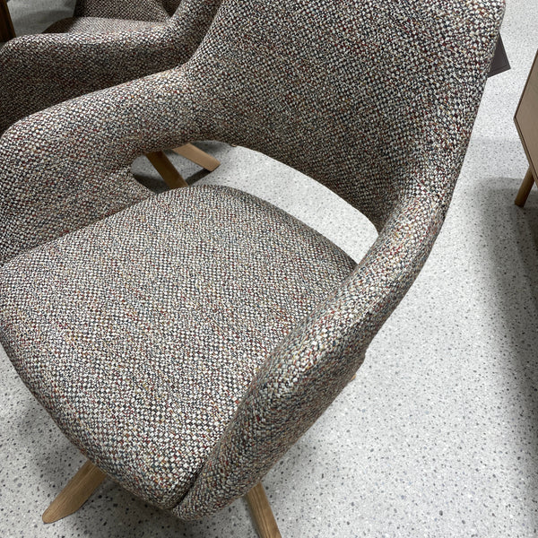 Speckled gray upholstered chair arm and seat with light wood legs