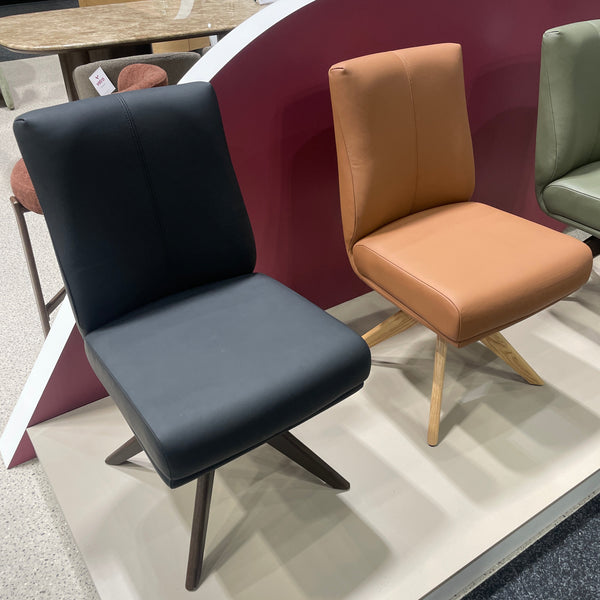 Pair of swivel chairs with leather seats, dark and tan, on angled bases