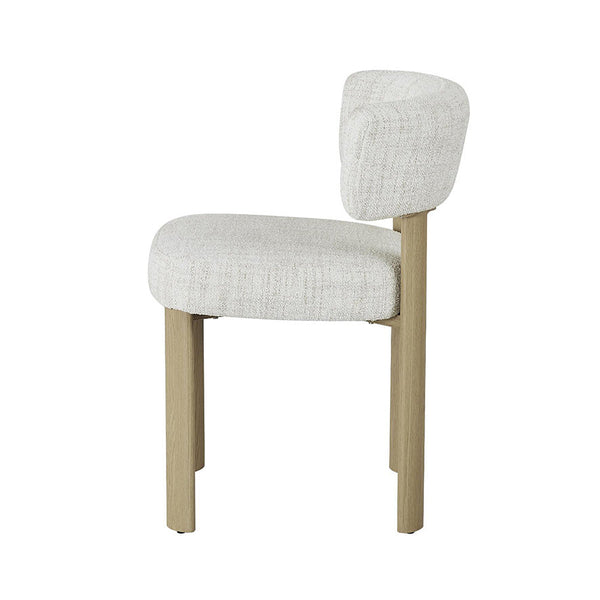 Light grey upholstered dining chair viewed from the side, rounded back and tapered square legs