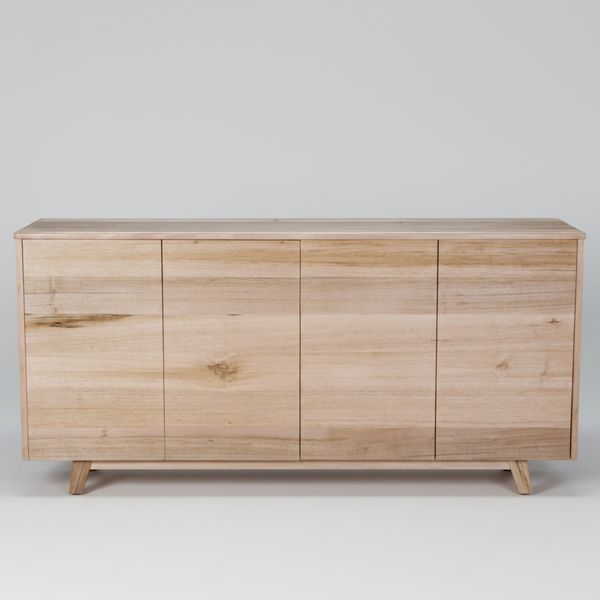 A light natural wood sideboard cabinet with four front doors, tapered legs, and a clean rectangular silhouette, shown against a plain white background.